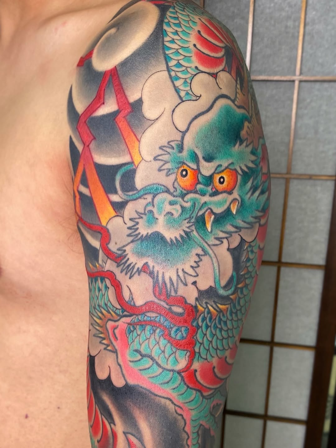 Vibrant Japanese dragon with teal scales and clouds