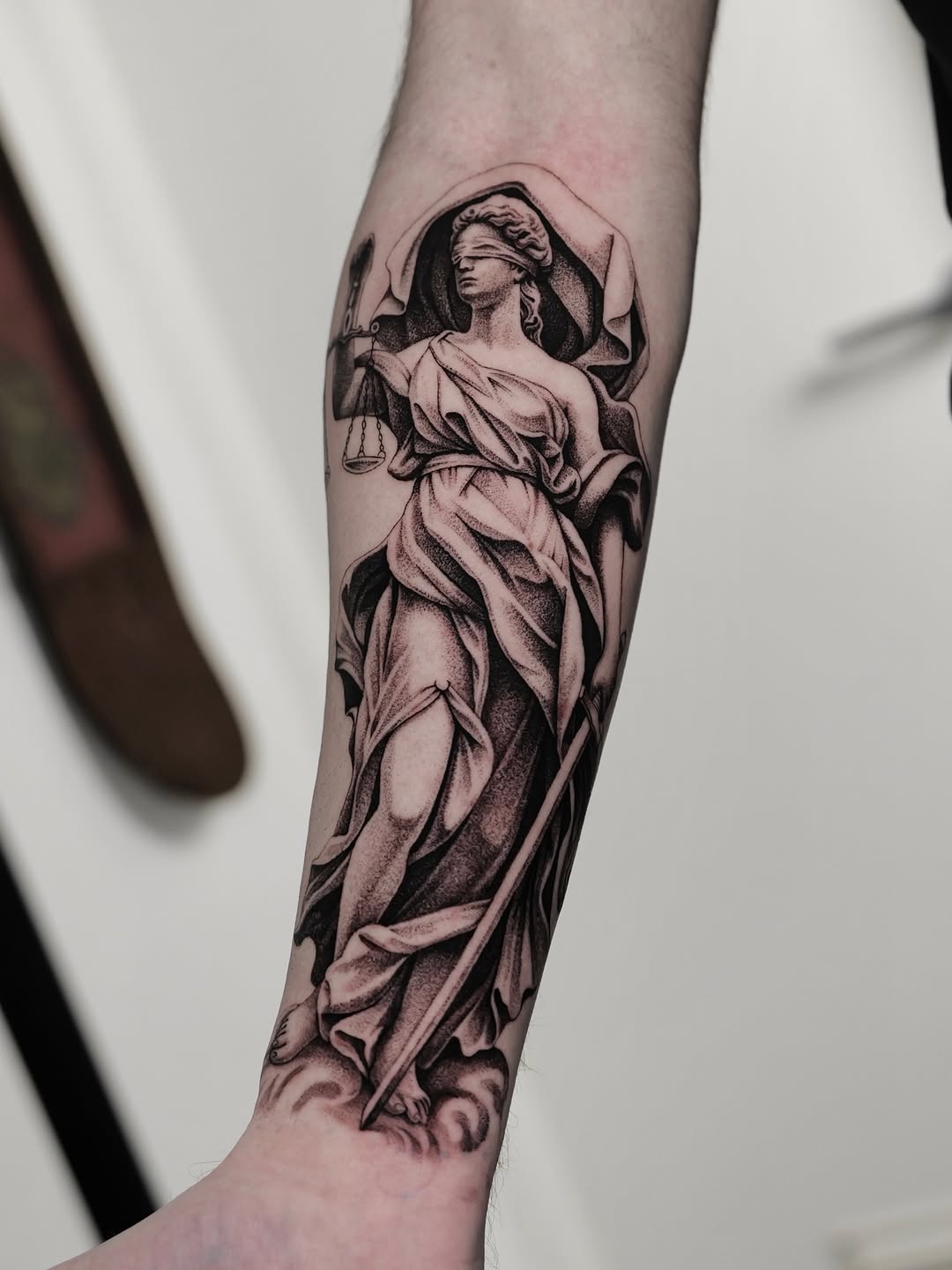 Classical Lady Justice in bold blackwork with stippled shading