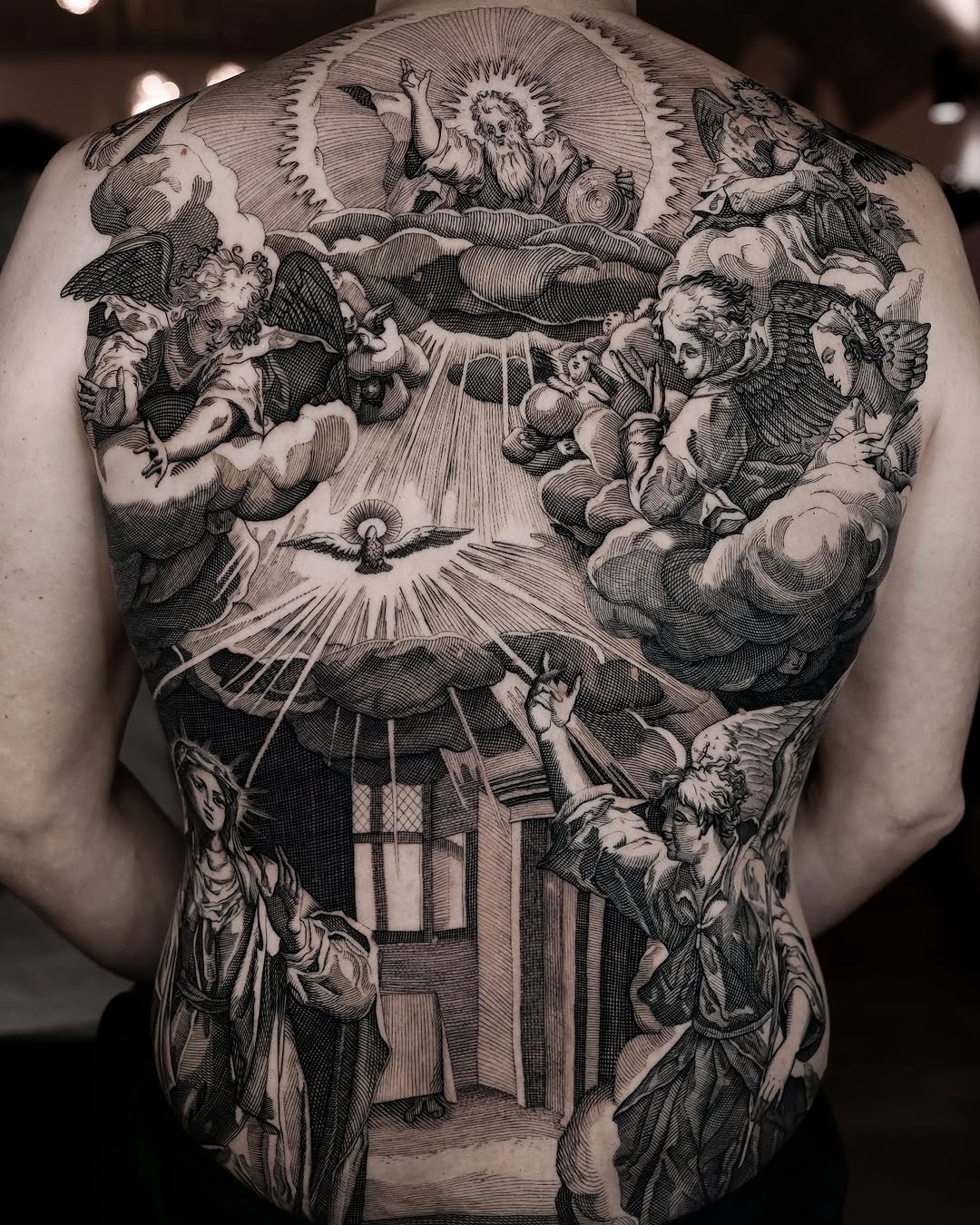 Intricate etching back piece depicting the Annunciation with angels