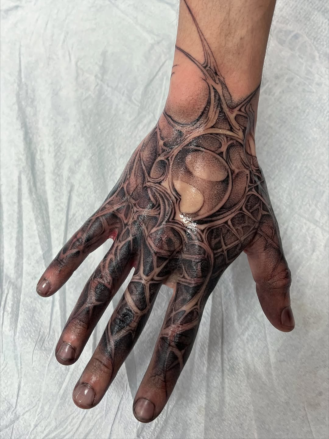 Intricate blackwork hand tattoo with organic geometric lattice