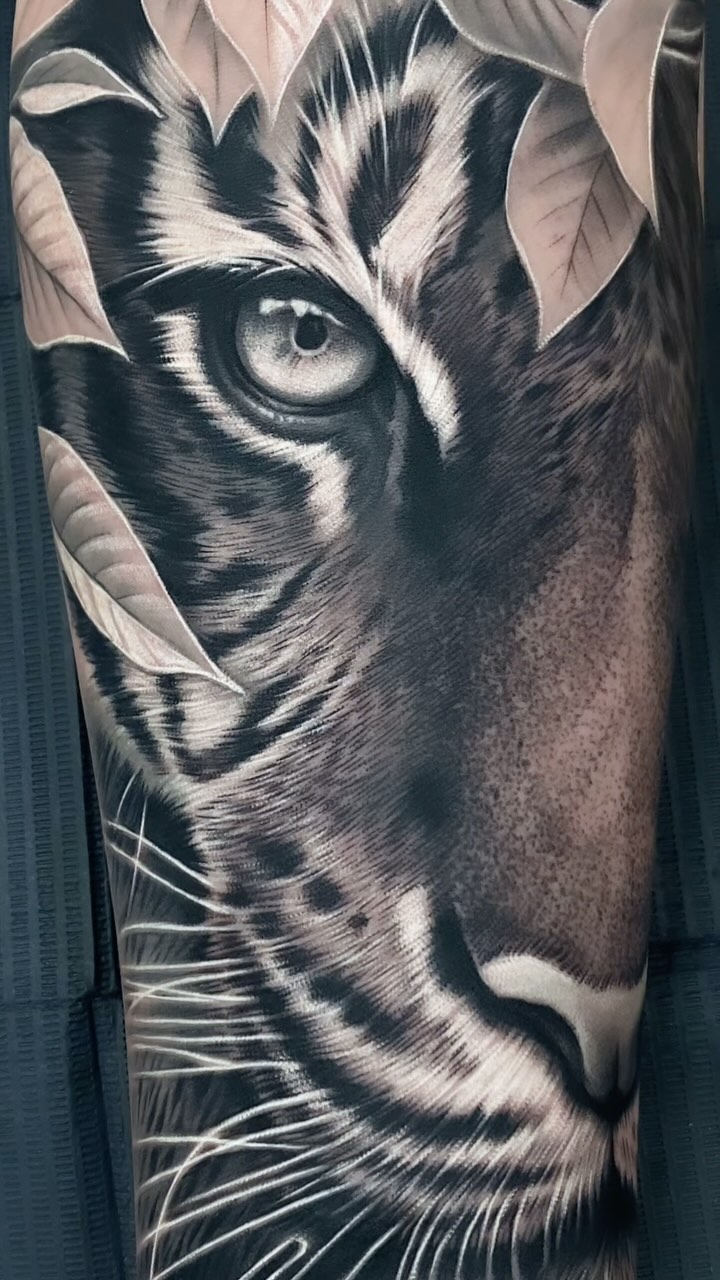 Hyper-detailed black-and-gray tiger portrait with leafy accents