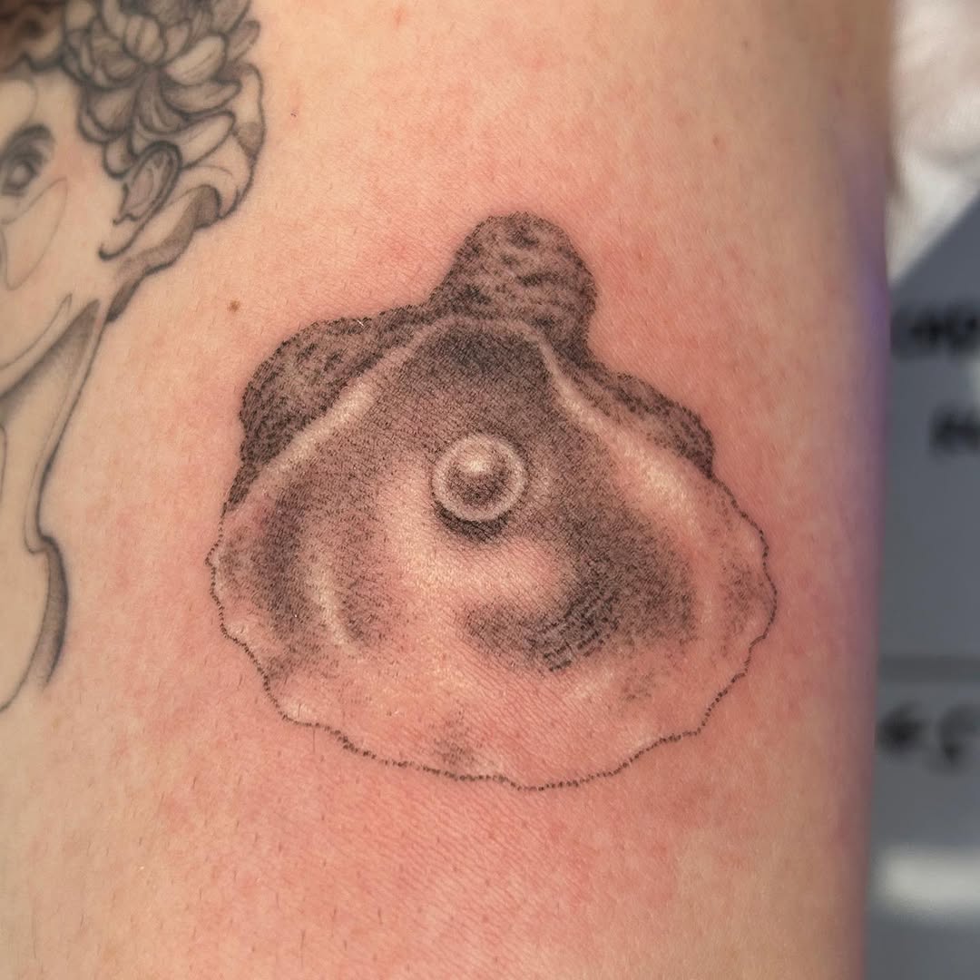Tiny shell with stippled shading and pearl-like center
