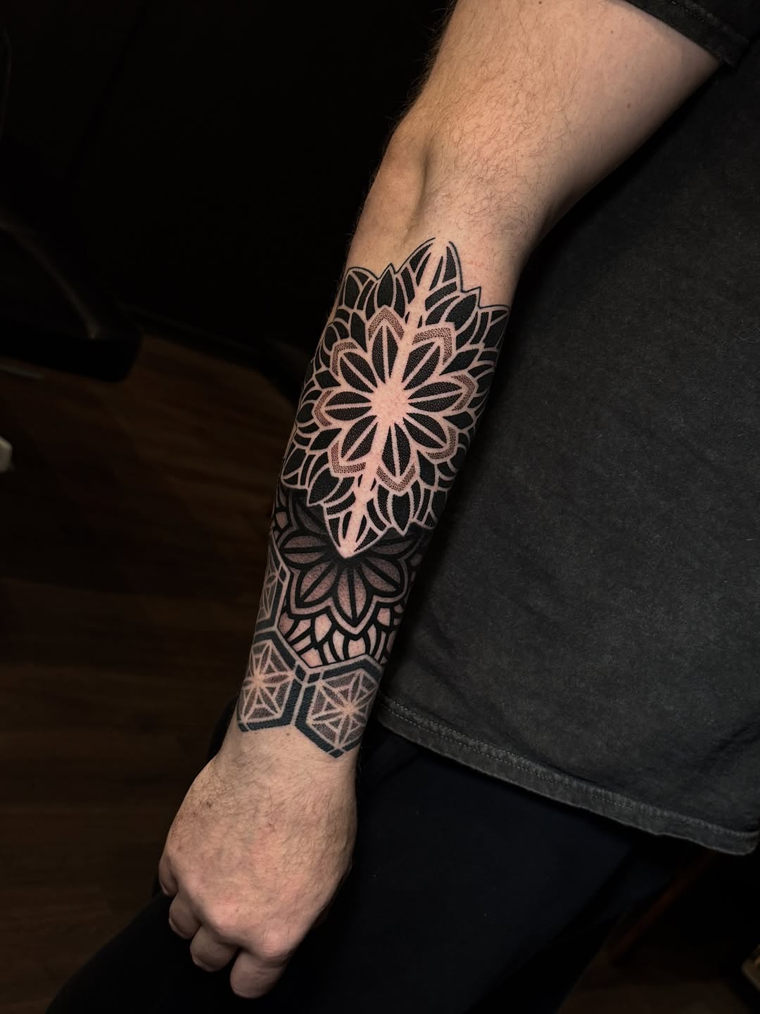 Intricate geometric forearm mandala with bold dotwork shading