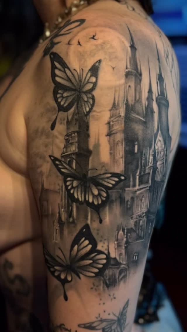 Bold blackwork butterflies drift over a moody cityscape.