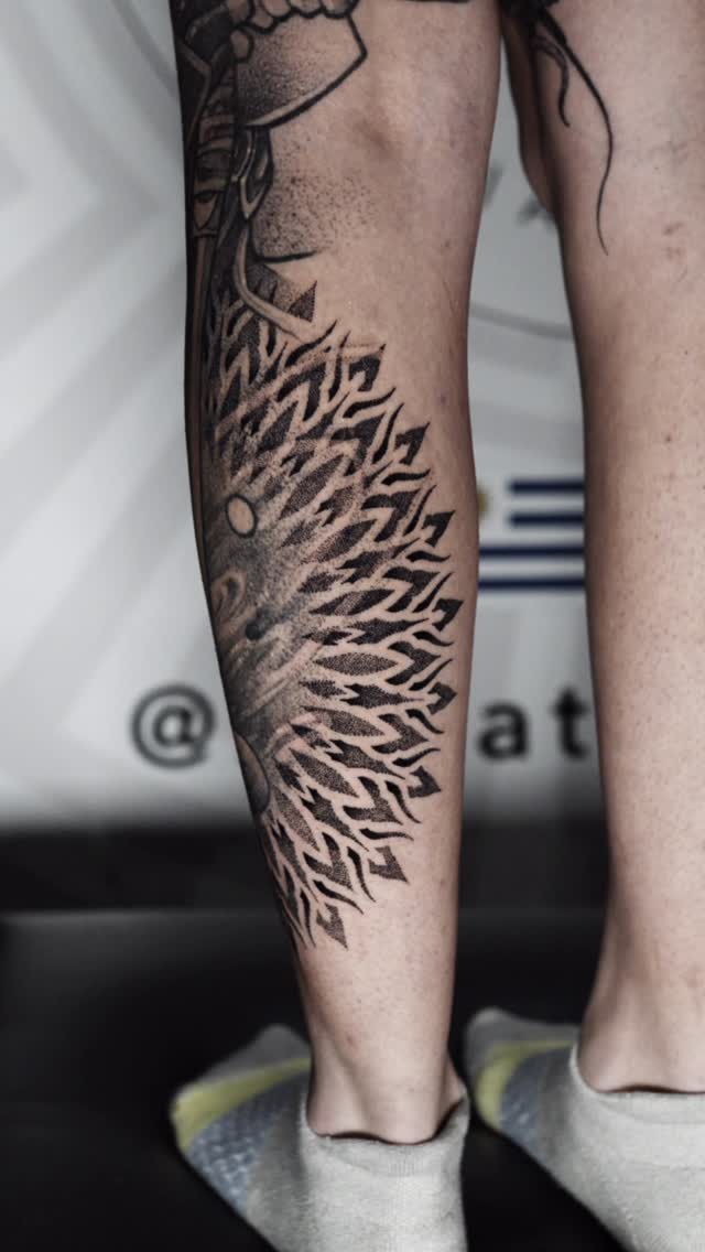 Dynamic blackwork geometric pattern spiraling along the calf