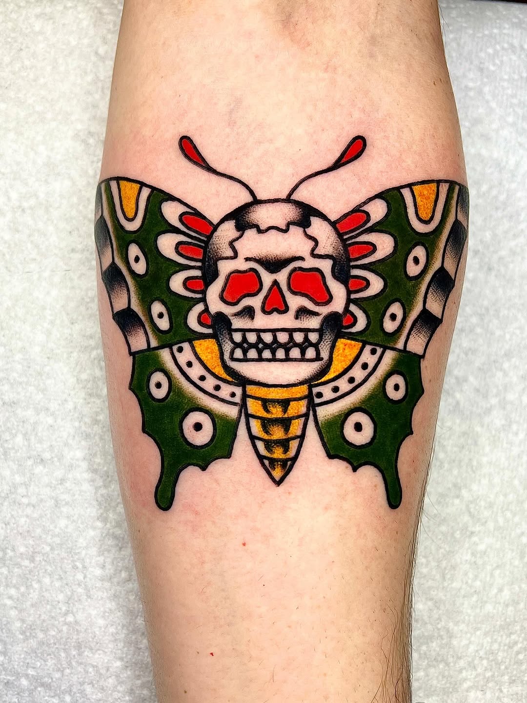 Bold skull-butterfly with neon red highlights.