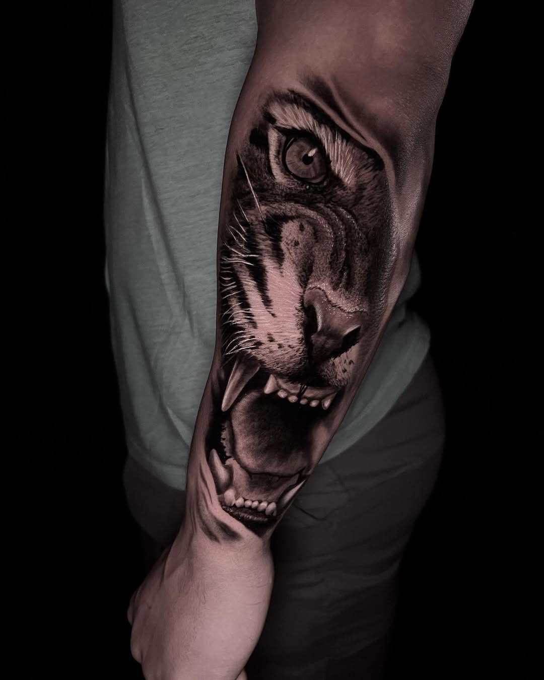Hyper-detailed tiger head with snarling maw on forearm.