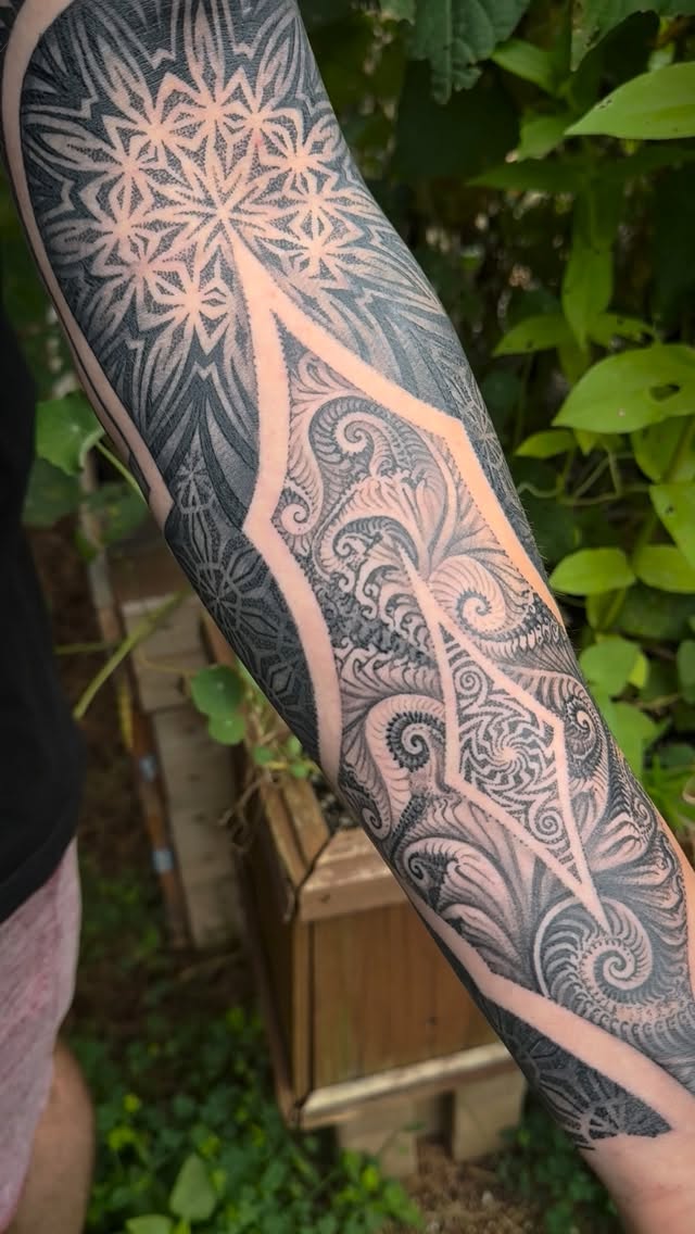 Intricate blackwork sleeve of fractal geometry and floral swirls