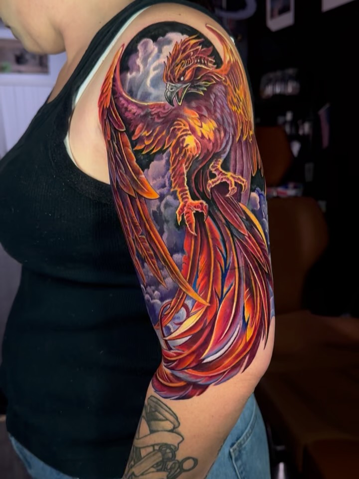 Fiery neo-traditional phoenix wraps the arm in blazing plumage