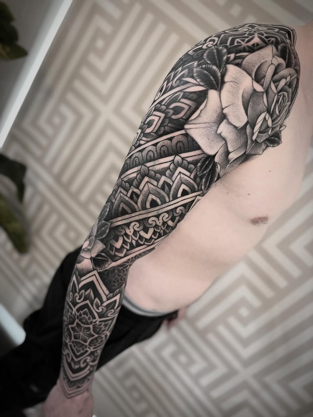 Intricate blackwork geometric sleeve with ornate rose motif