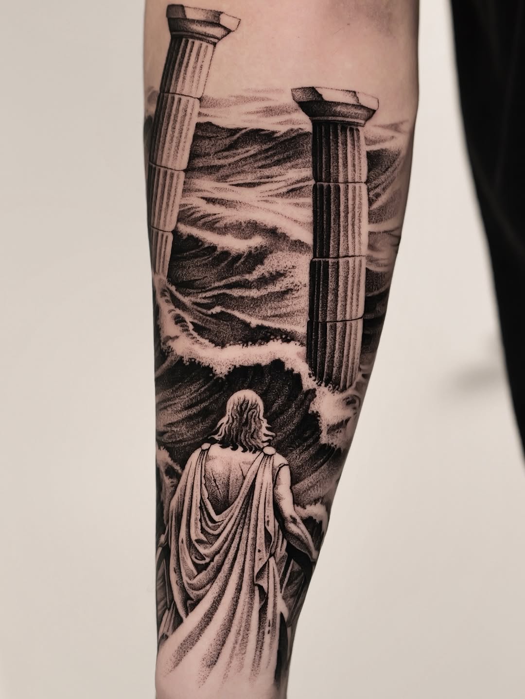 Monumental ancient columns rise above turbulent seas, ghostly figure