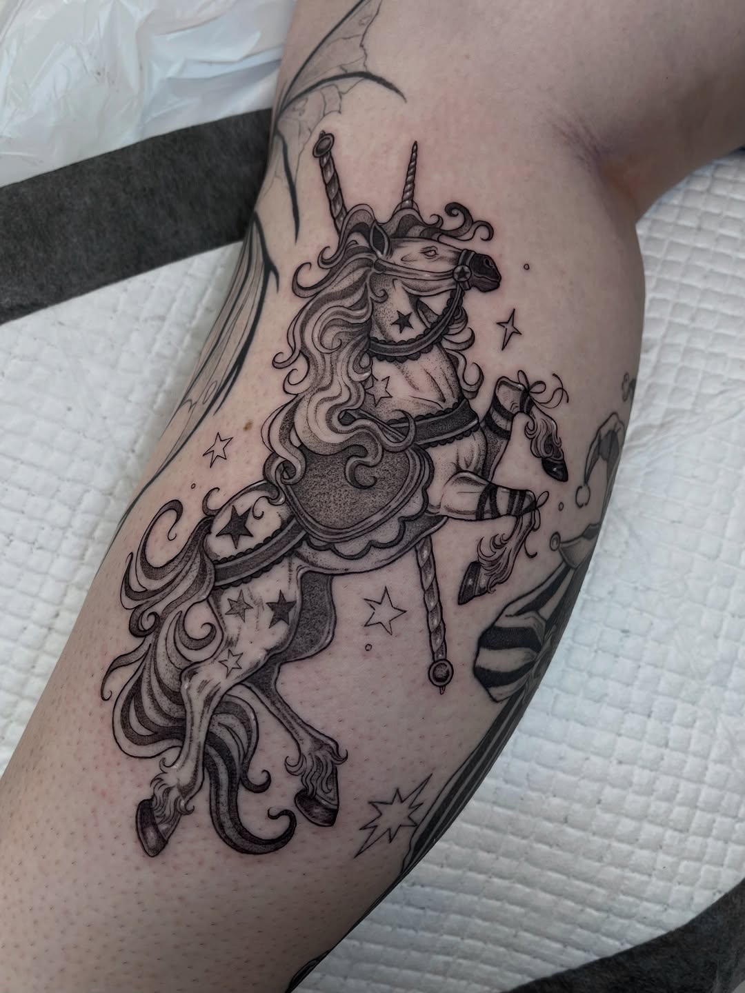 Elegant, ornate carousel horse tattoo with scrolling mane and stars