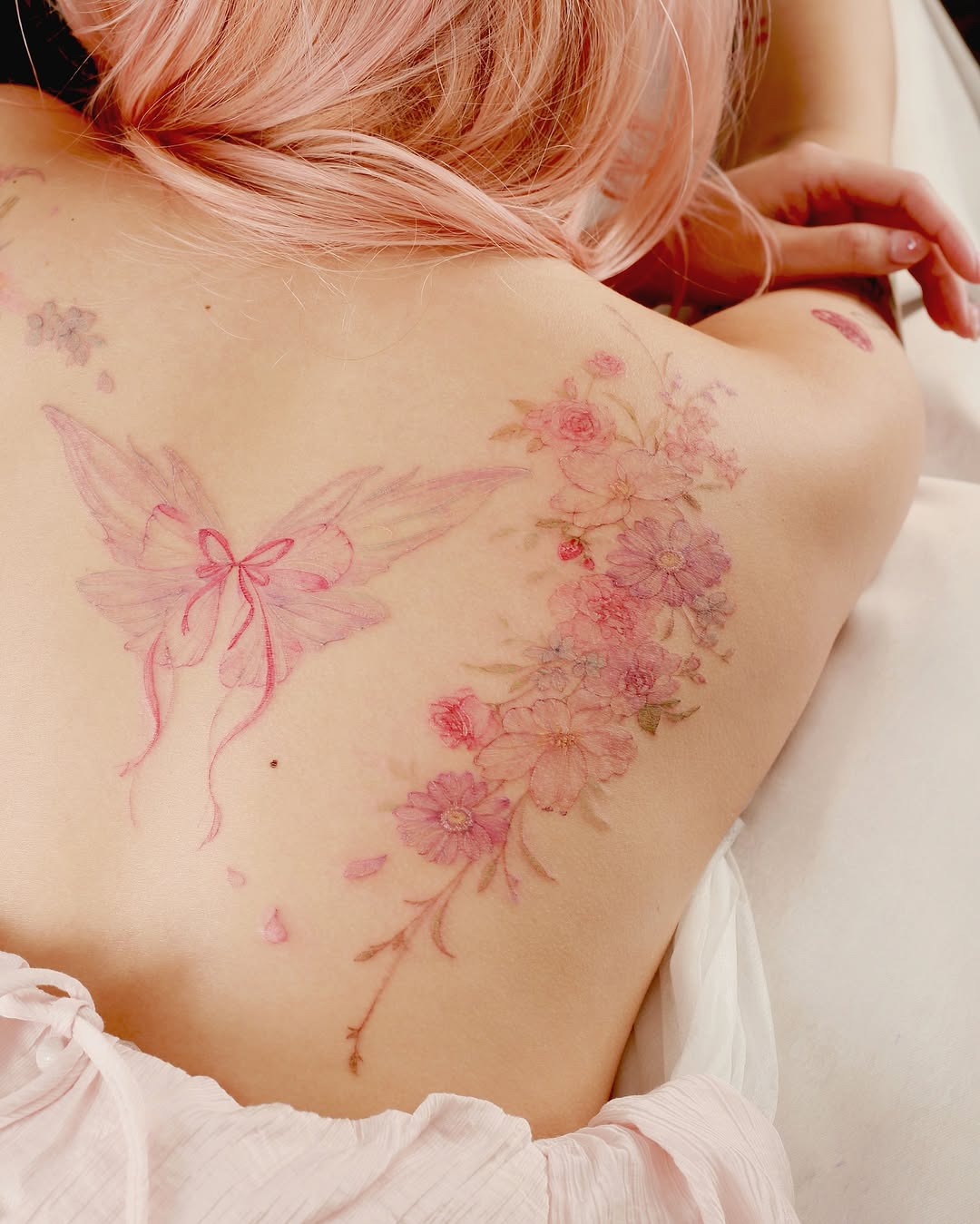 Delicate pink watercolor blossoms entwine a butterfly on back