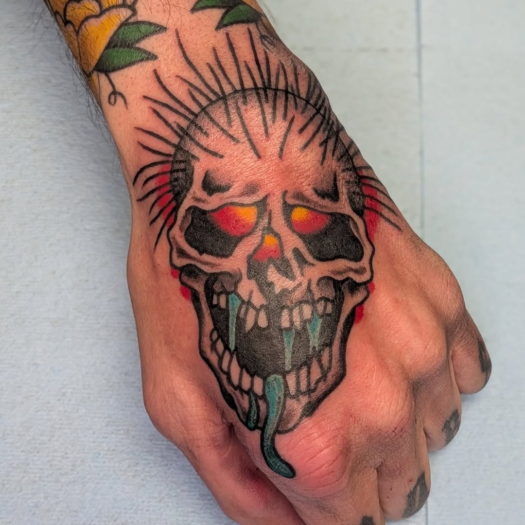 Bold skull tattoo with neon red eye sockets and tongue