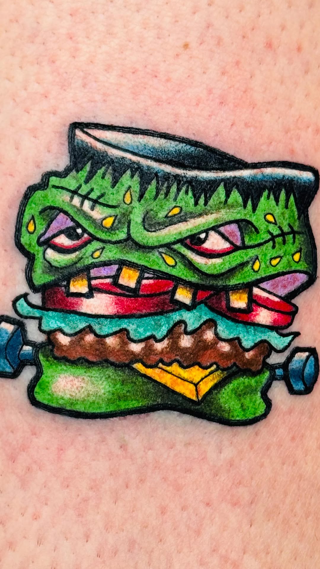 Bold neon-green monster-burger tattoo with chunky outlines