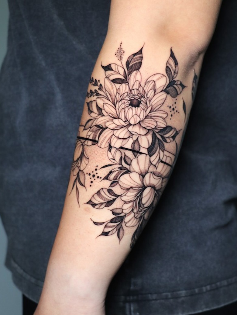 Elegant fine-line floral wrap around forearm, airy and delicate