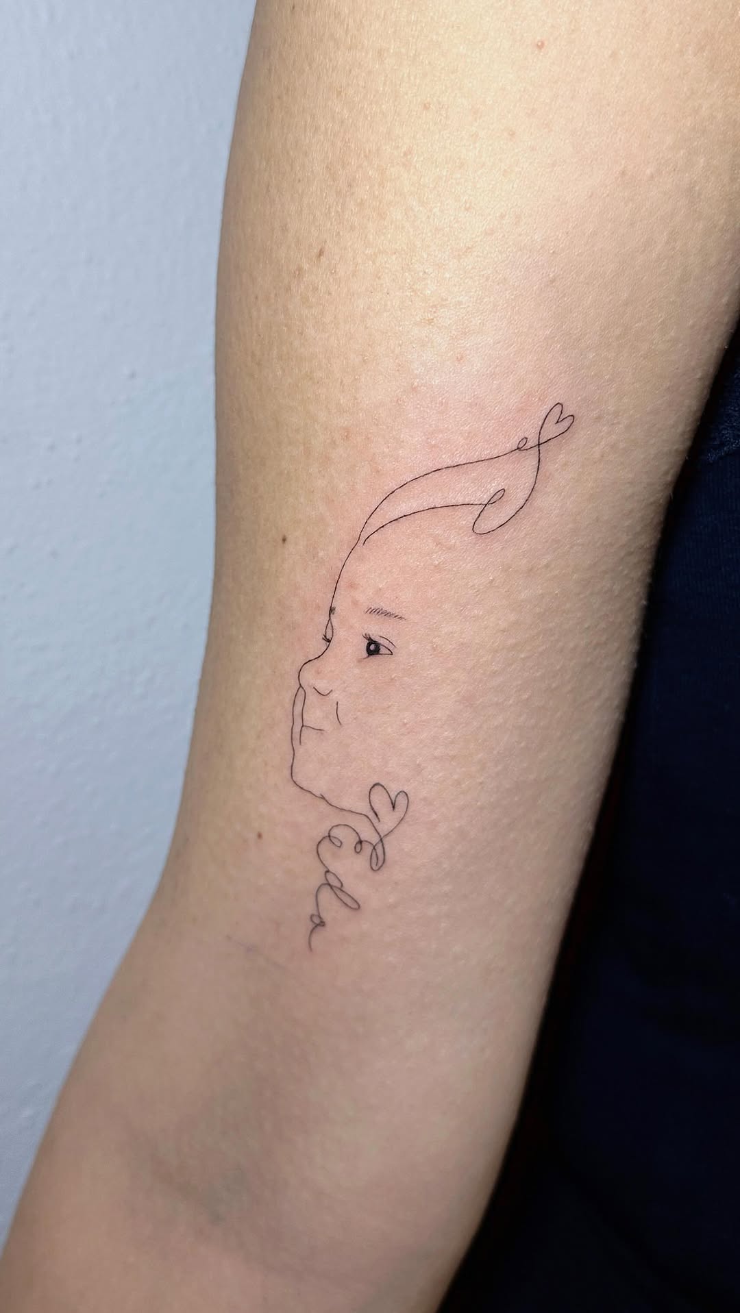 Minimalist baby-face line art with flowing cursive script