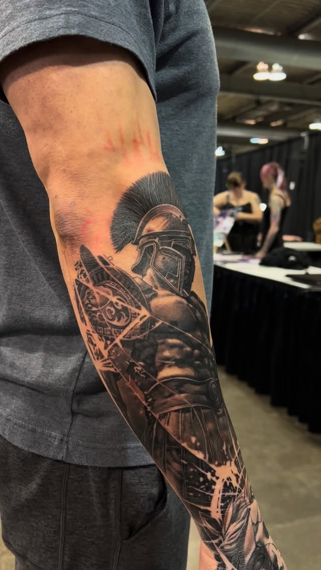 Bold black-and-gray Spartan helmet with shattered shield.