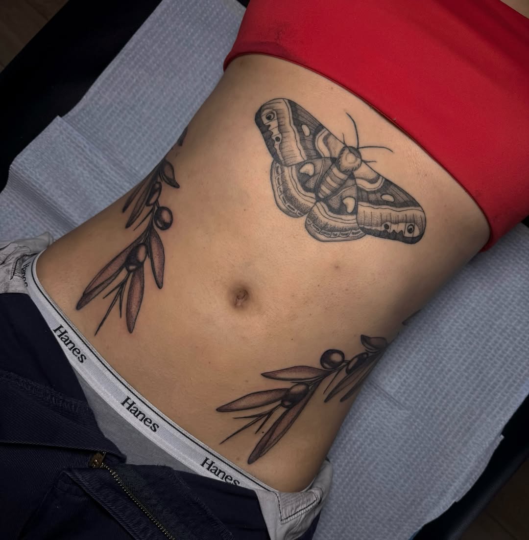 Bold black moth with delicate olive-branch accents