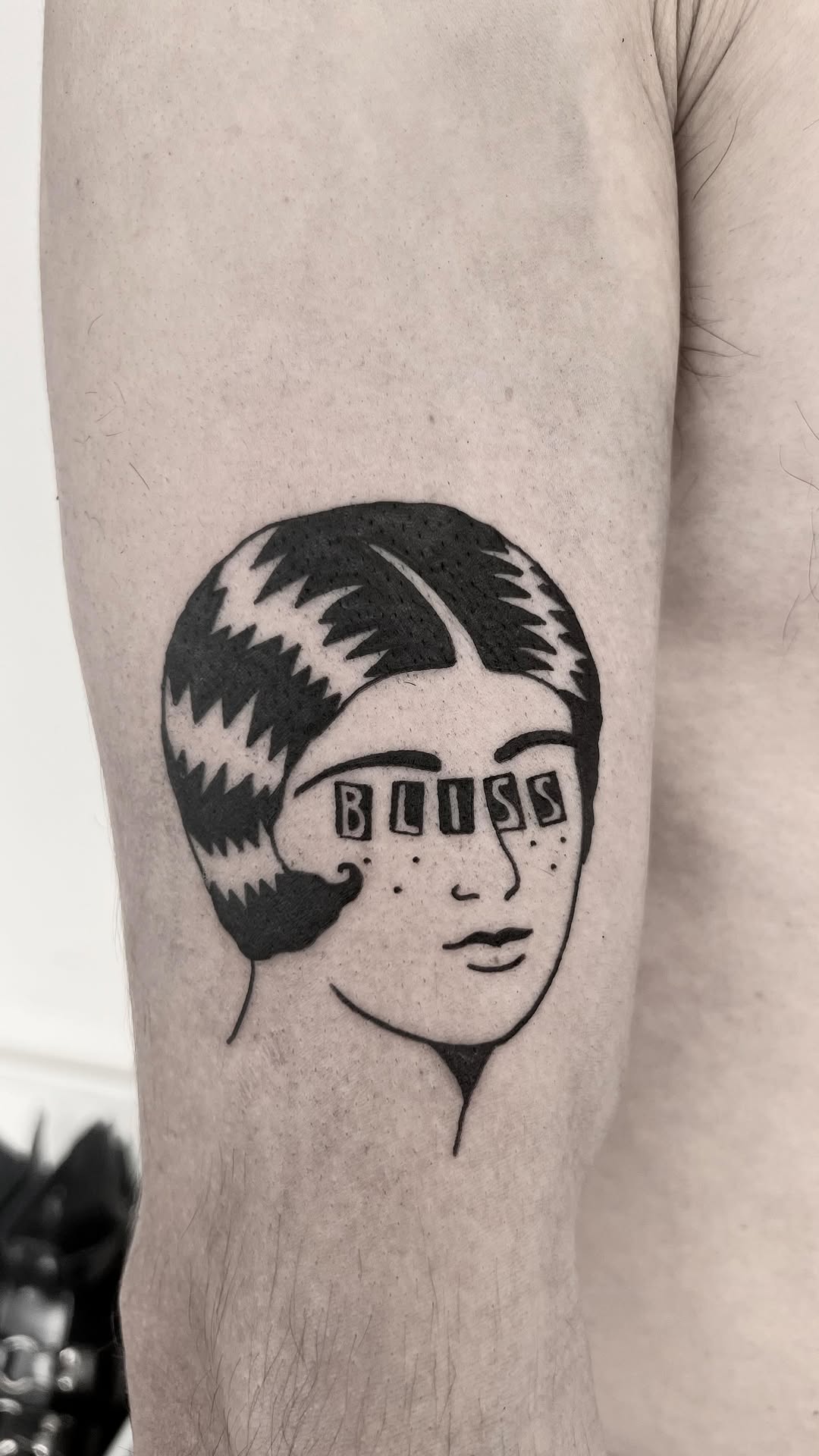 Bold black-line female head with 'BLISS' across eyes.