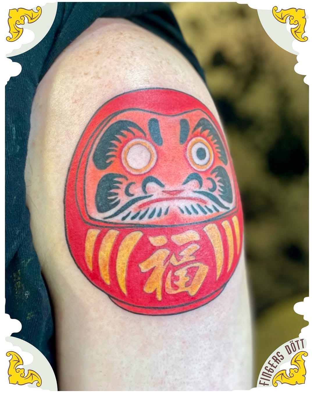 Bold red Daruma doll with black facial details.