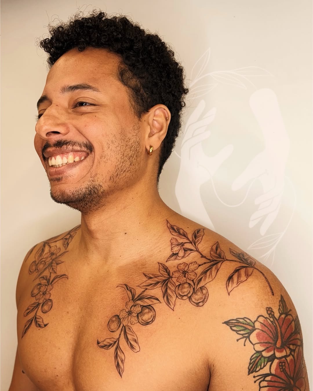 Intricate, symmetrical botanical chest-and-shoulder floral tattoo with shading