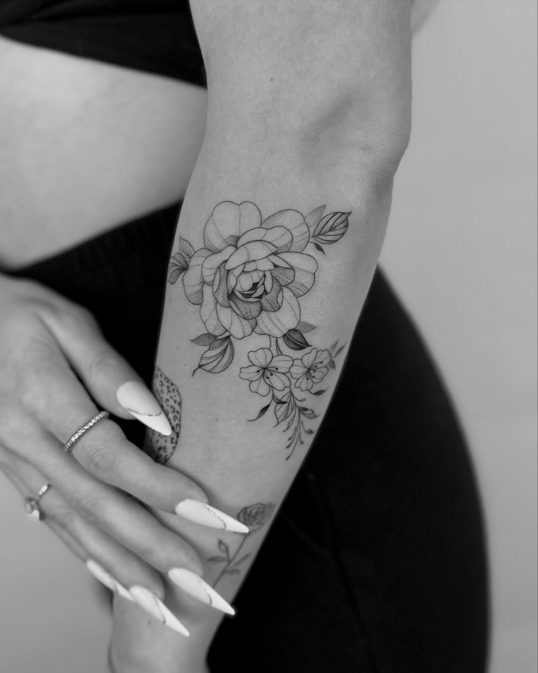 Delicate black-and-gray floral forearm piece with fineline petals