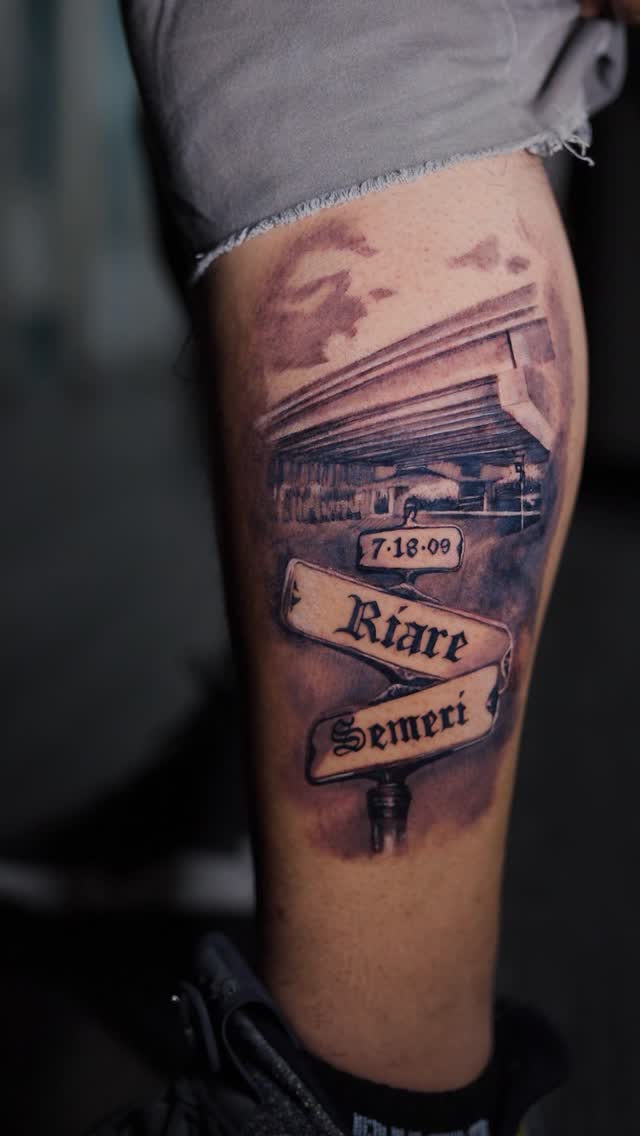 Monumental black-and-gray memorial sign with date banners