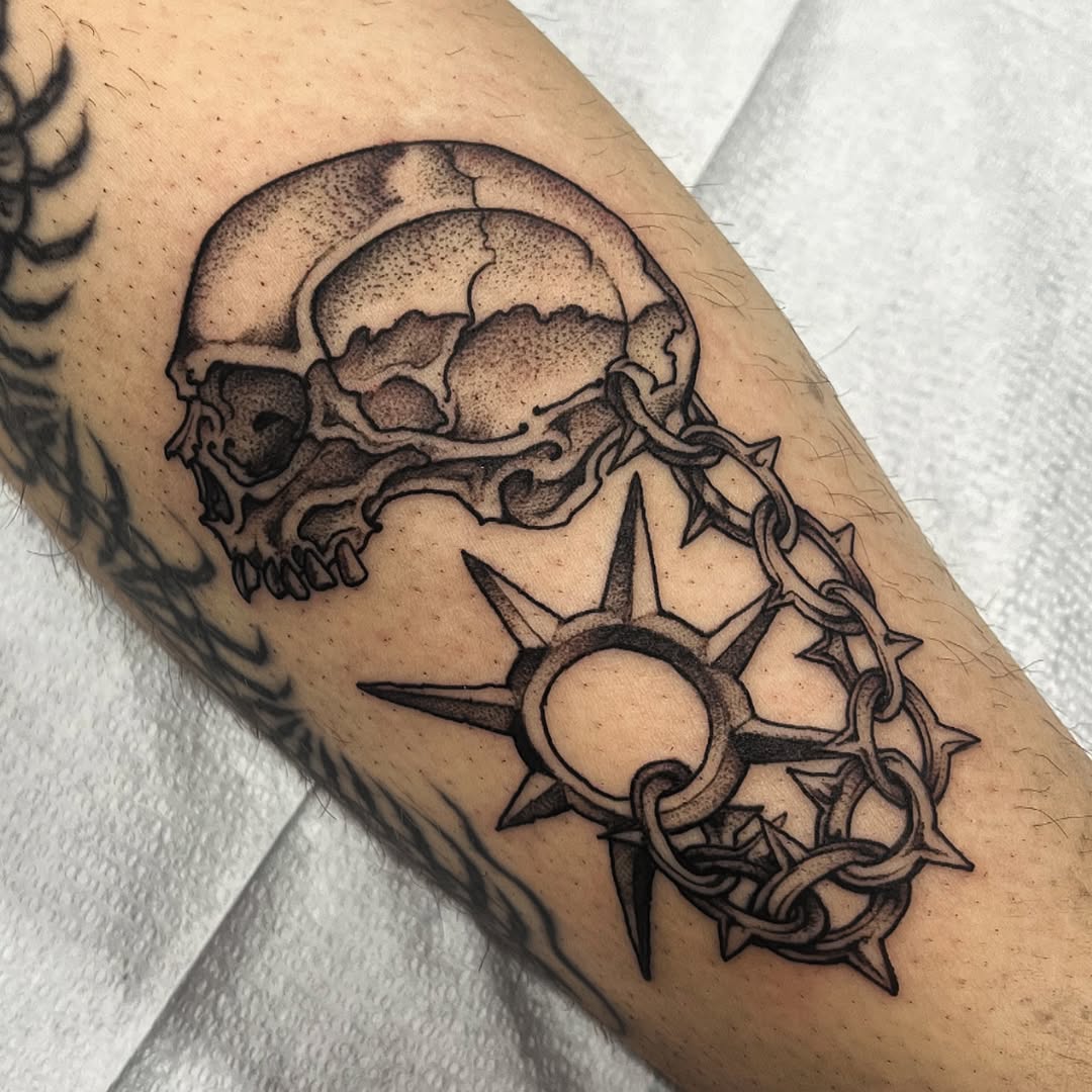 Bold skull with barbed chain and radiant sun motif