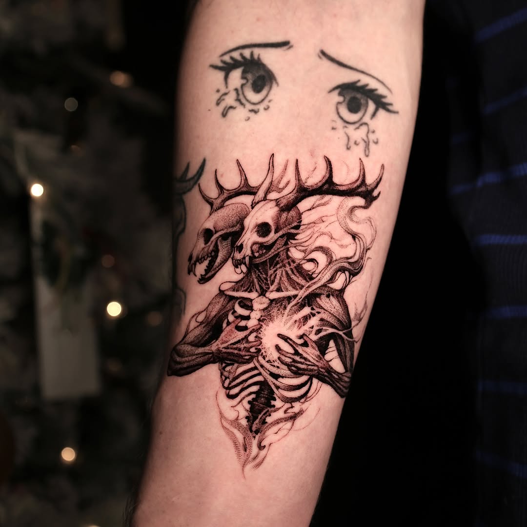 Demonic skulls entwined in smoky ink on forearm