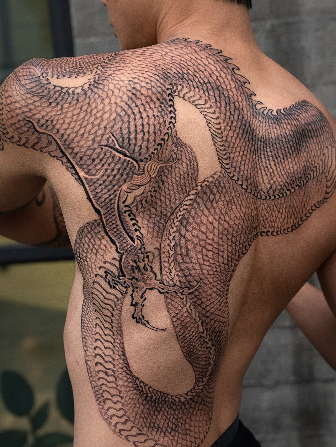 Coiled black dragon with dense scales and bold linework