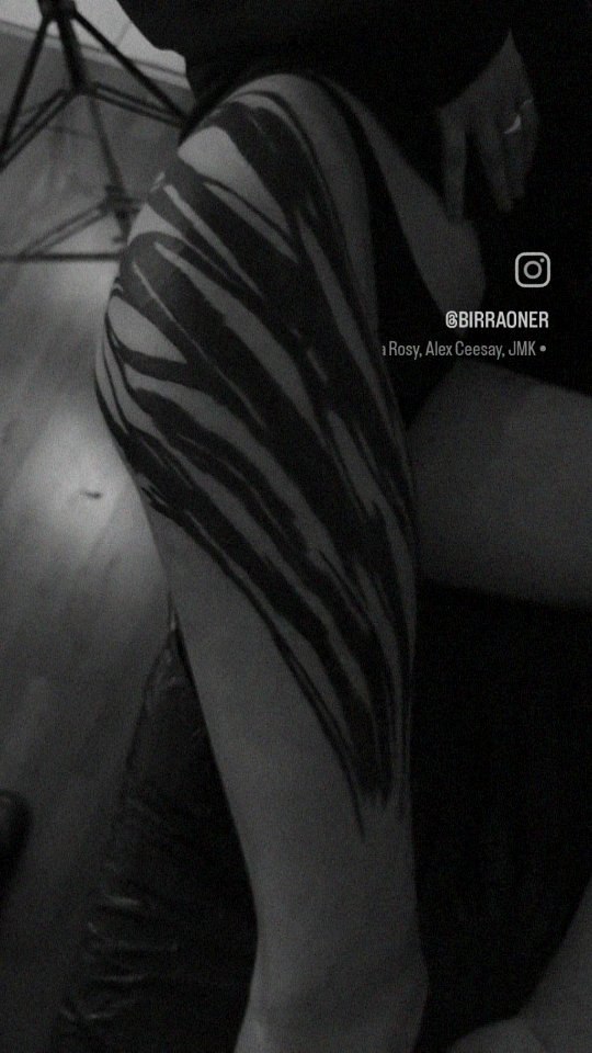 Bold black zebra-stripe leg tattoo in high-contrast monochrome