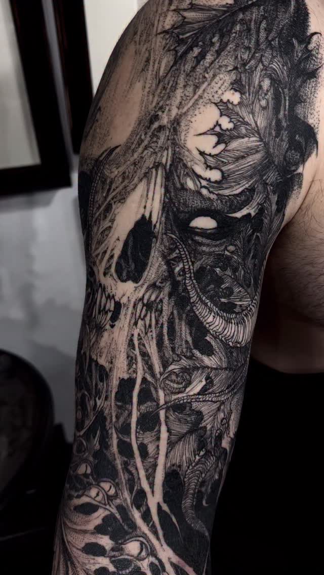 Intricate blackwork sleeve with skull motifs and vines