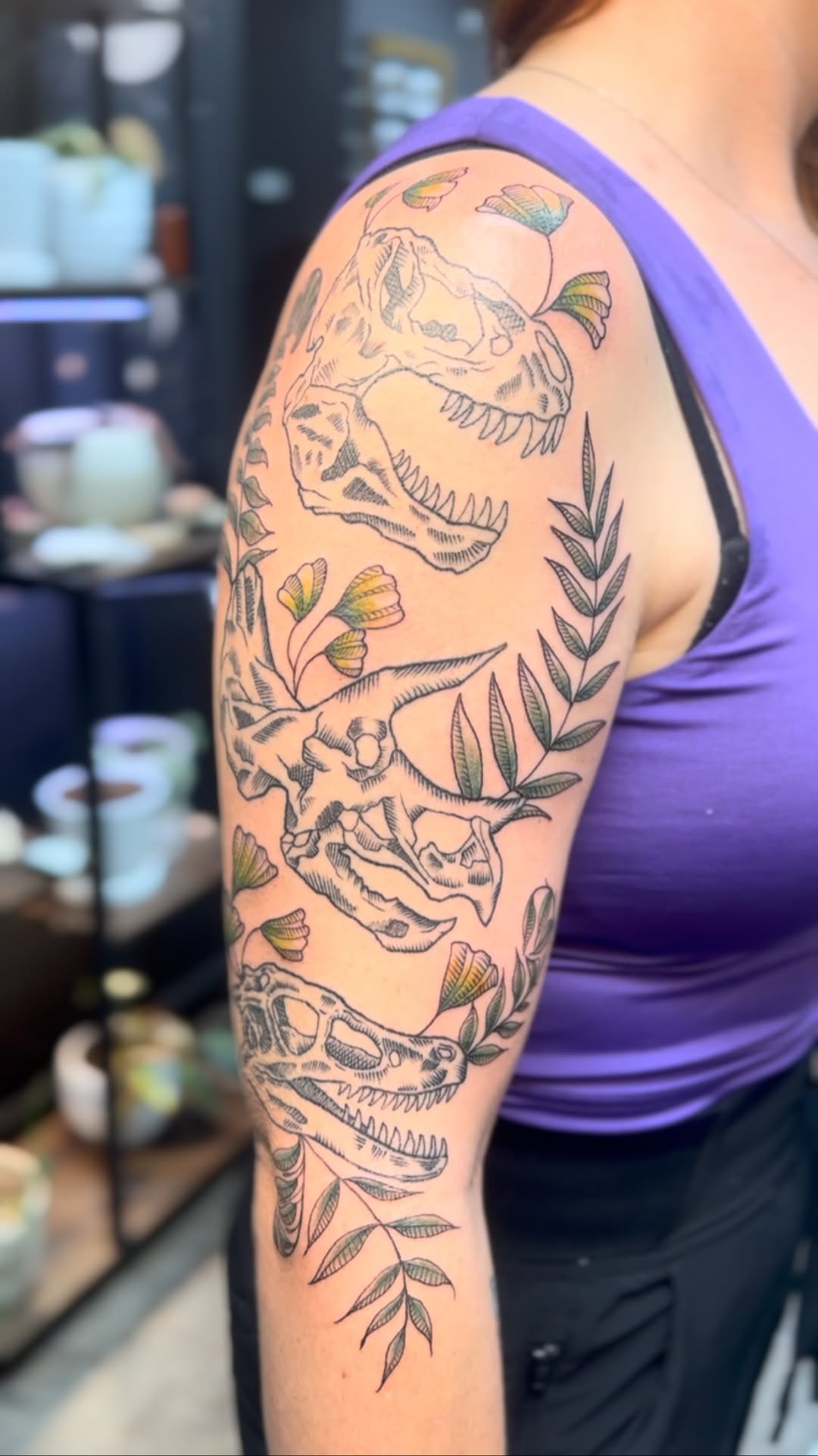 Bold dinosaur skulls entwined with leafy botanical sleeve