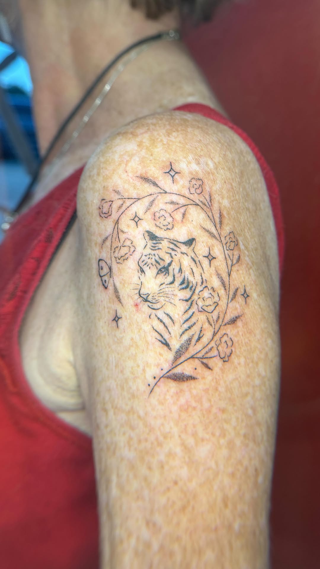 Delicate tiger head encircled by blooming floral vines