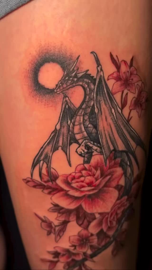 Dramatic black dragon entwined with vibrant red blossoms
