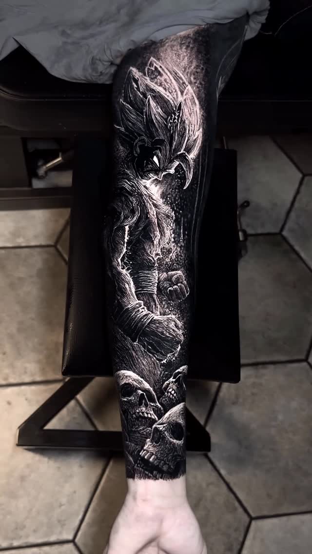 Dark black-and-gray forearm sleeve with skulls and a Goku-inspired figure