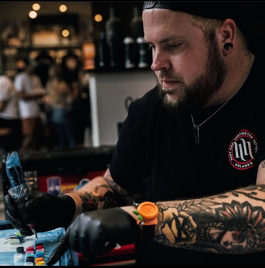 Intricate floral-blackwork forearm tattoo in progress.