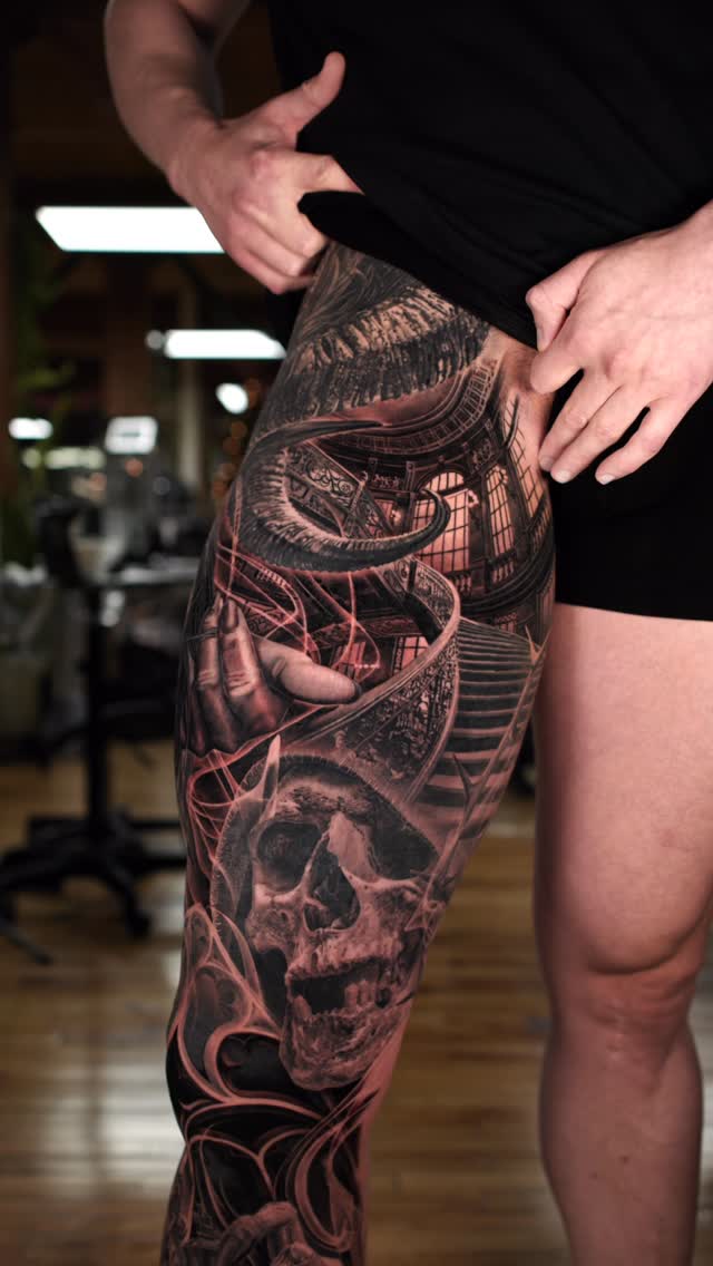 Monumental black-and-gray leg sleeve with skulls and arches