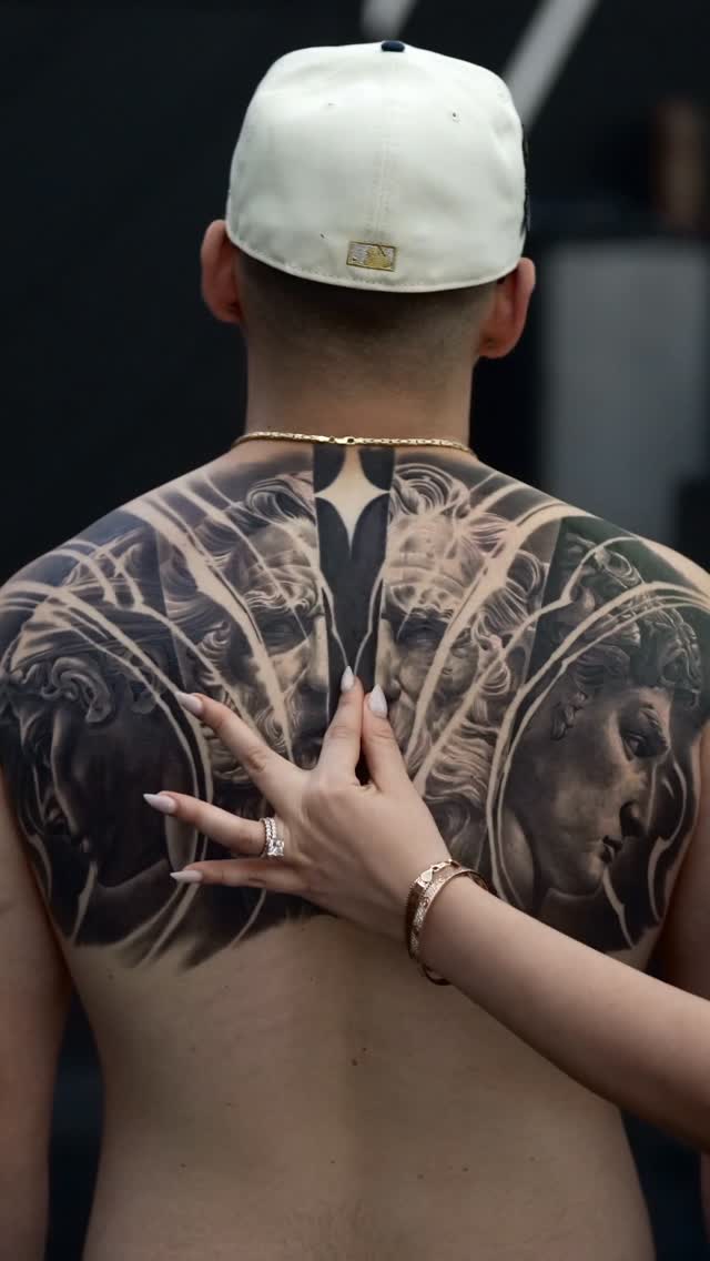 Monumental grayscale back piece with sculpted faces