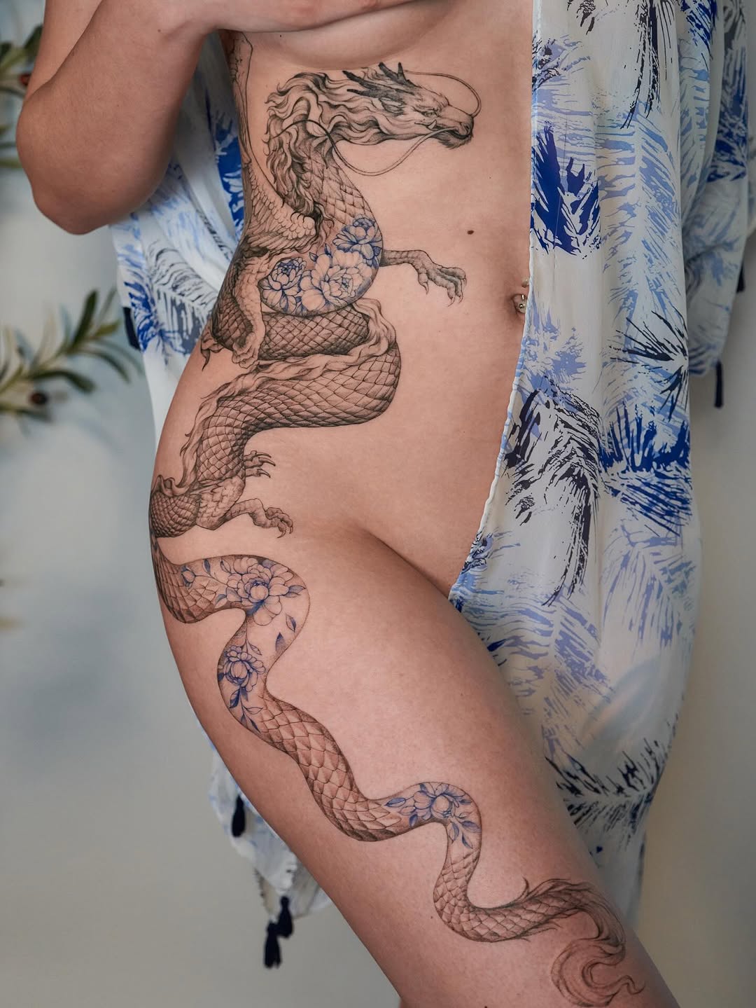 Elegant, sinuous dragon tattoo with floral shading accents