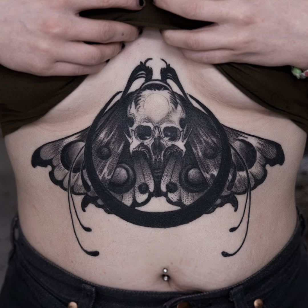 Bleak death-moth skull with ornate black wings.