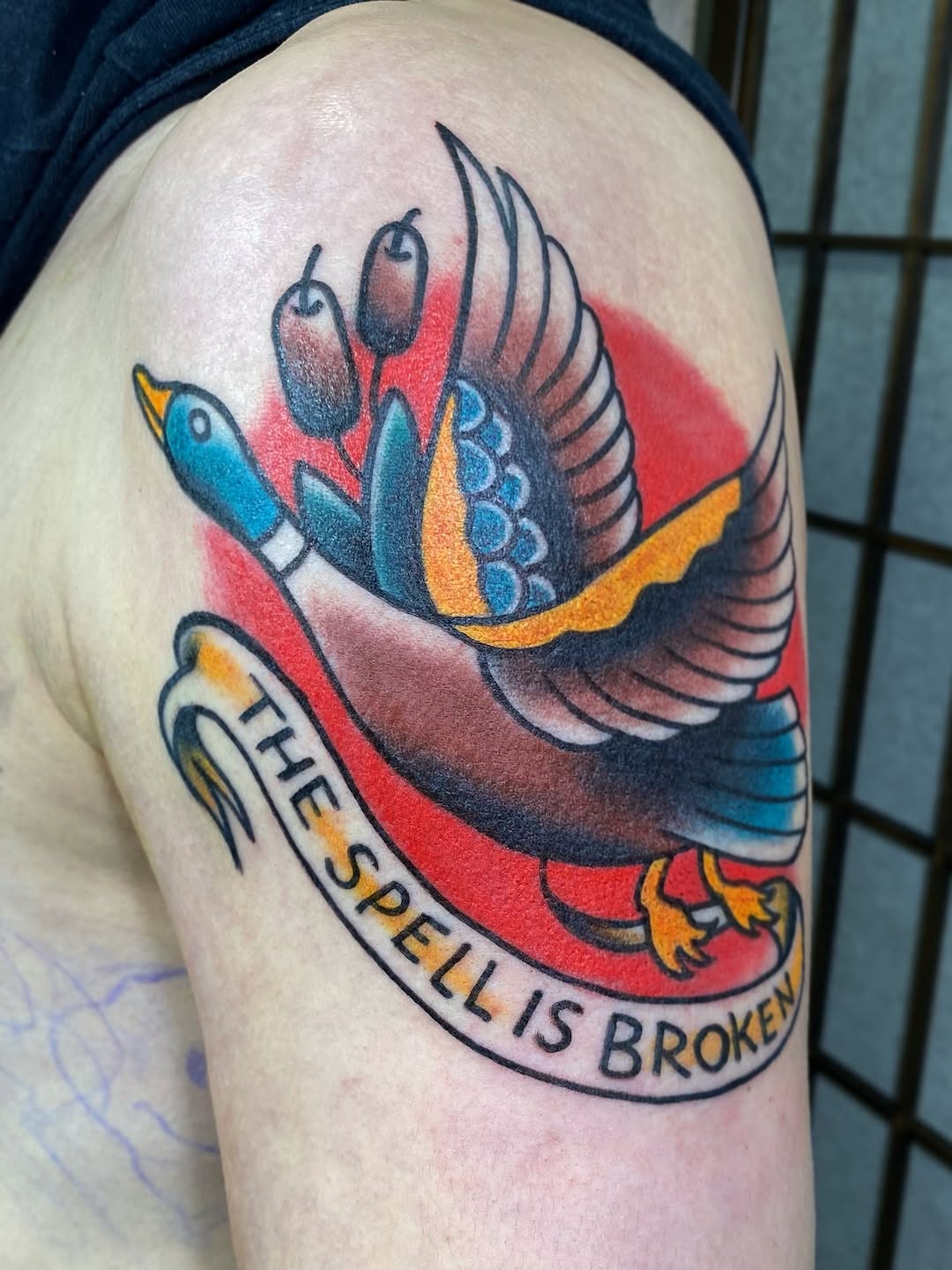 Bold traditional duck tattoo with bright colors and banner