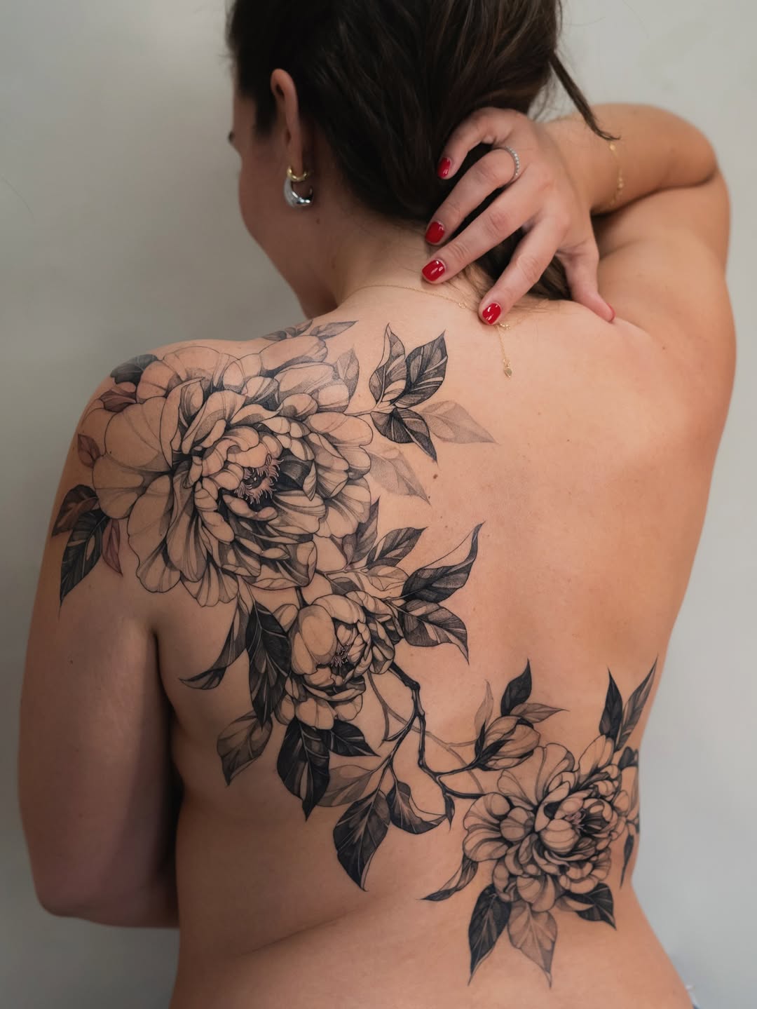 Intricate black-and-gray peony back-piece with lush leaves