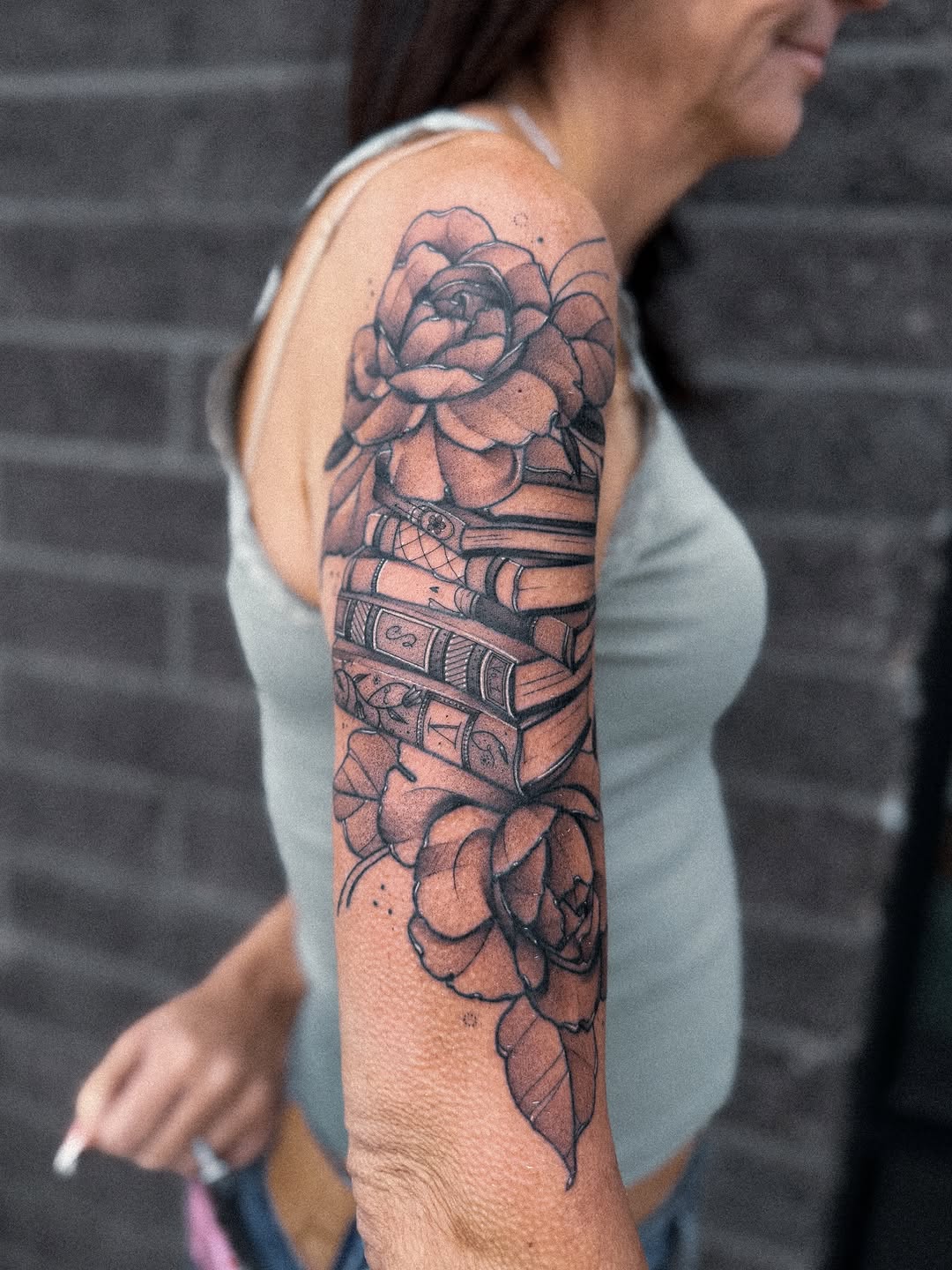 Ornate blackwork sleeve intertwining roses and stacked books