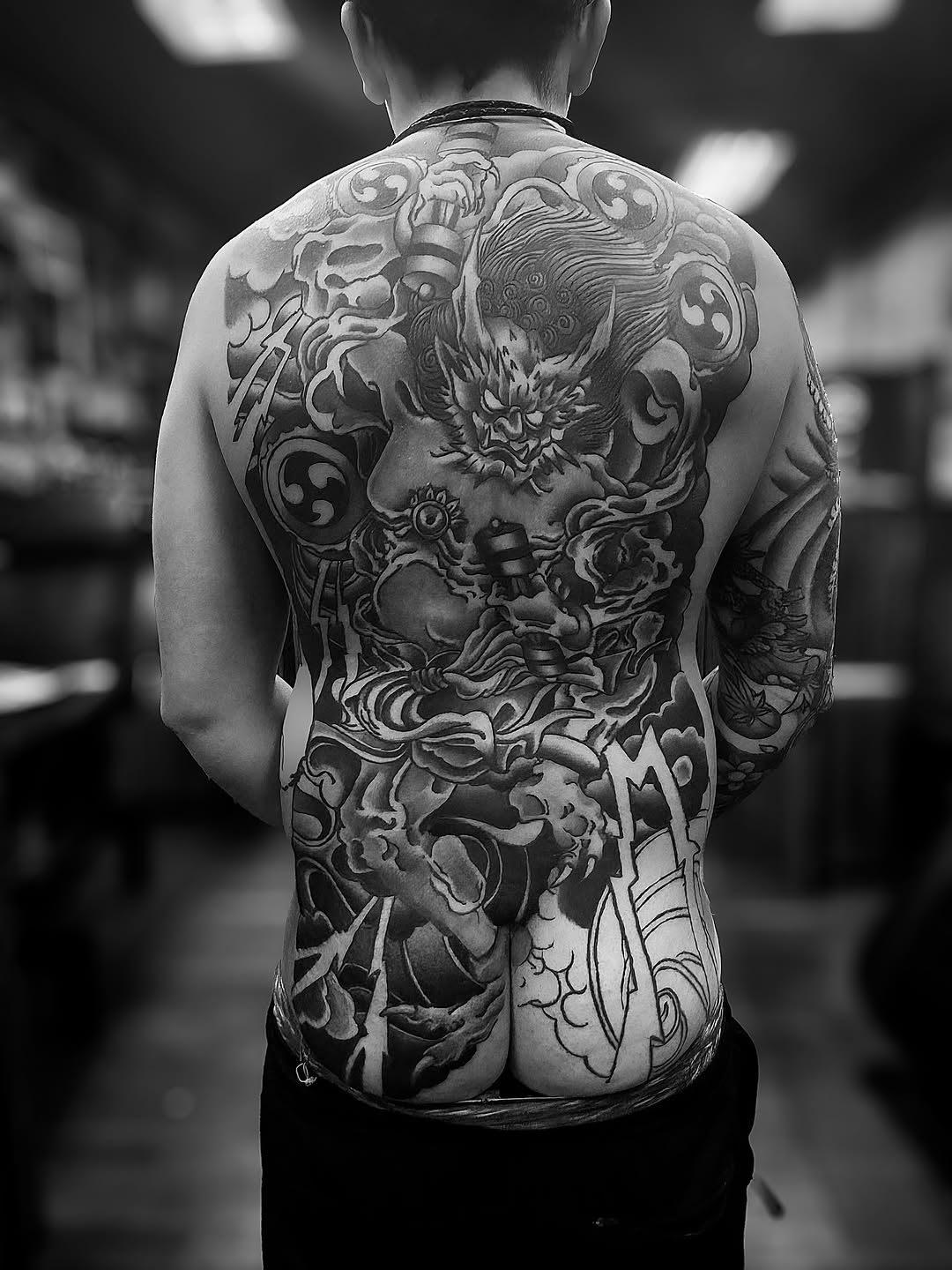 Monumental Japanese backpiece: ferocious demon-dragon amid clouds.