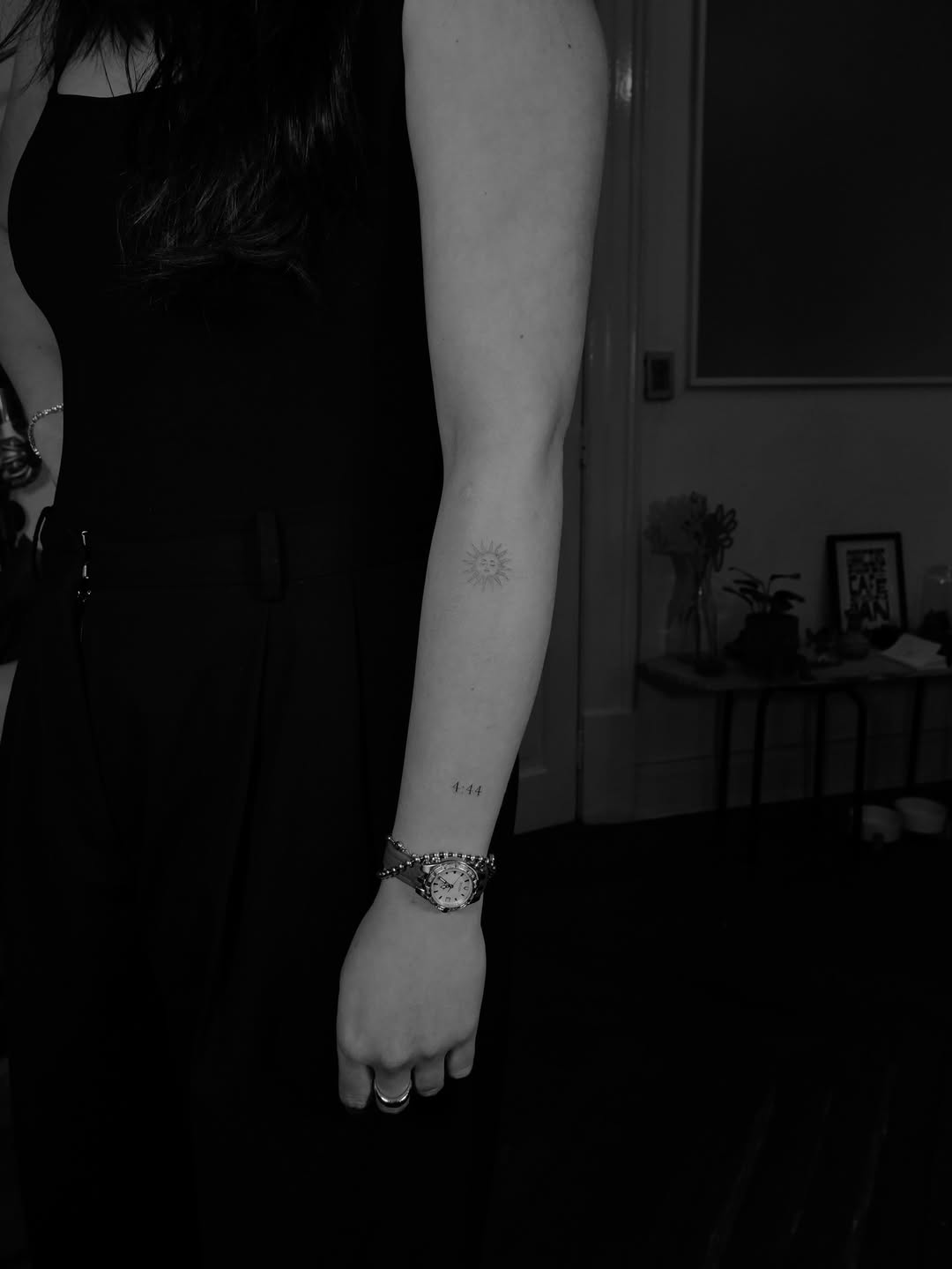 Delicate fine-line sun symbol with minimalist '4:44' digits.