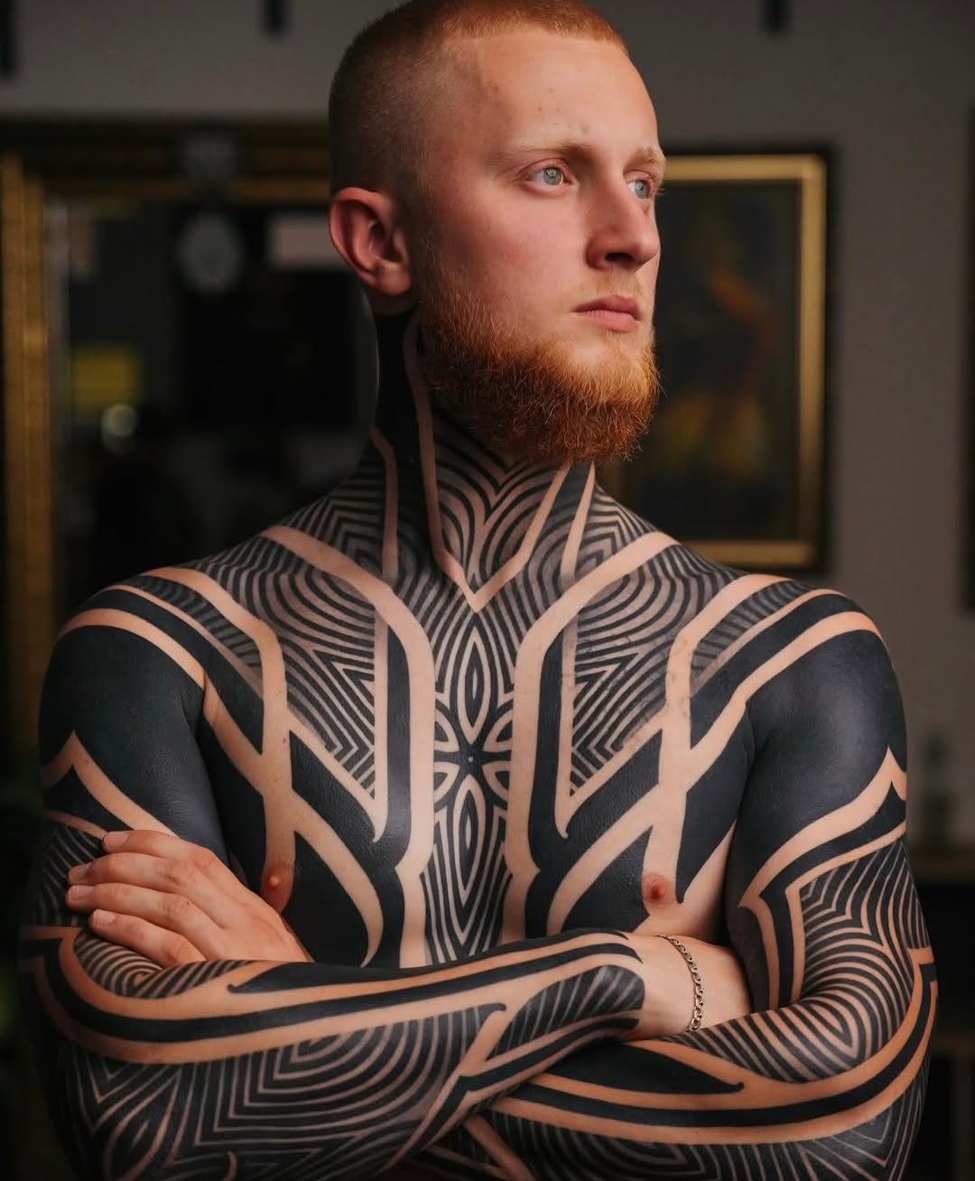 Intricate blackwork geometric chest and arm tattoo.