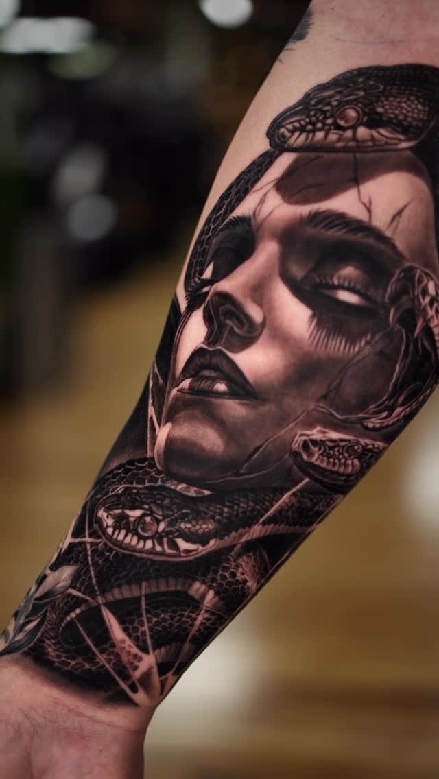 Hyper-realistic Medusa portrait with coiled snakes on forearm