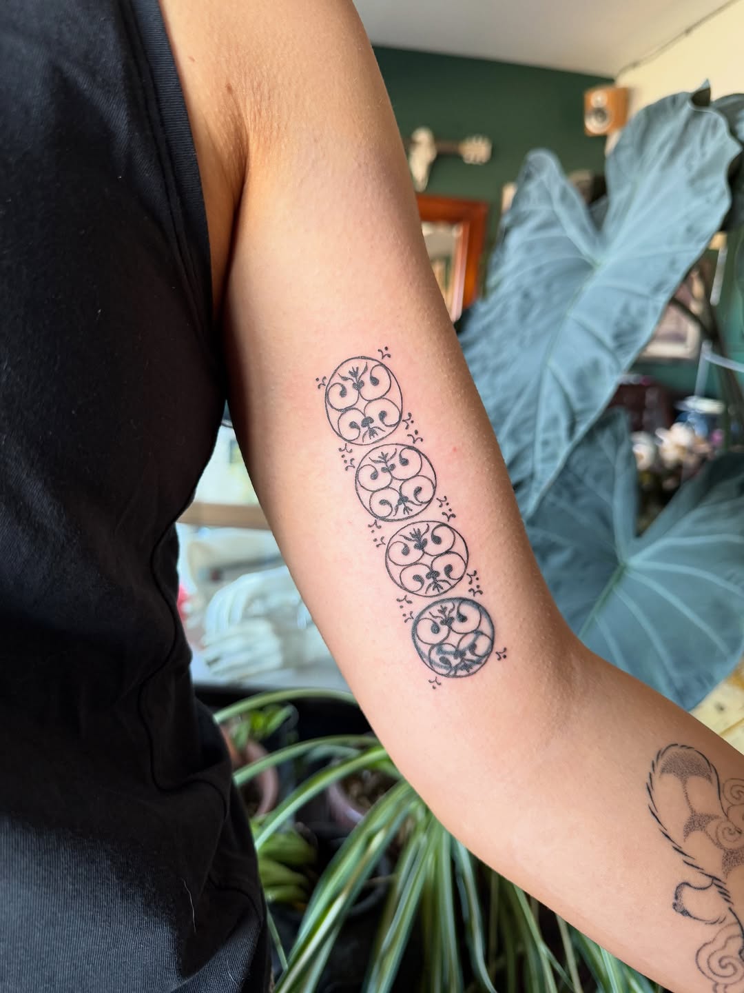 Five stacked circular garland motifs in delicate fineline